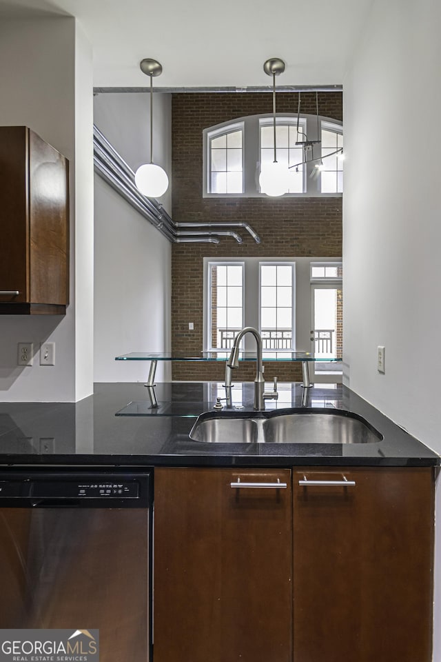 kitchen with a sink, dark stone countertops, dishwasher, and dark brown cabinets