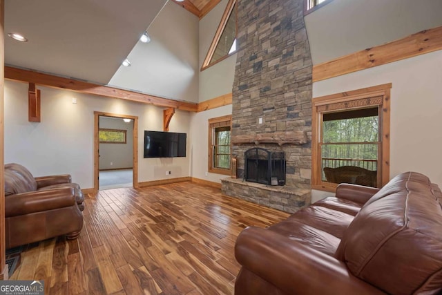142 Holland Dam Dr, Maysville, GA 30558 - living room with a high ceiling, a stone fireplace, baseboards, and wood finished floors