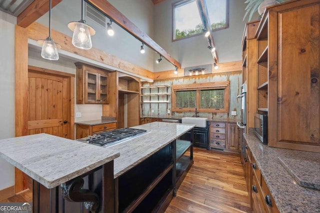 142 Holland Dam Dr, Maysville, GA 30558 - kitchen with open shelves, brown cabinetry, a kitchen island, and appliances with stainless steel finishes