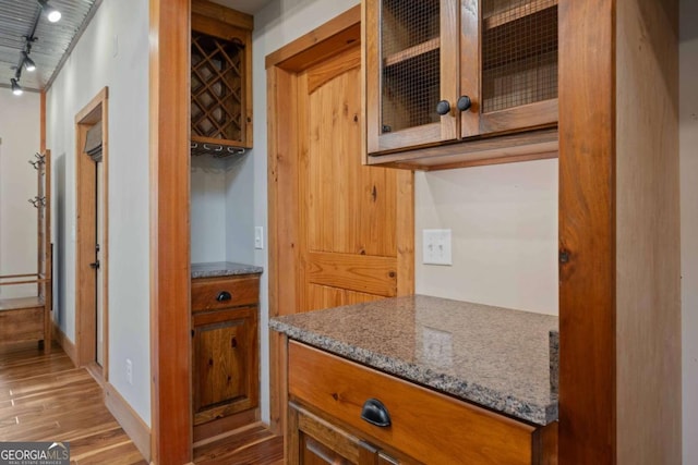 142 Holland Dam Dr, Maysville, GA 30558 - kitchen with rail lighting, glass insert cabinets, brown cabinets, and light wood-type flooring