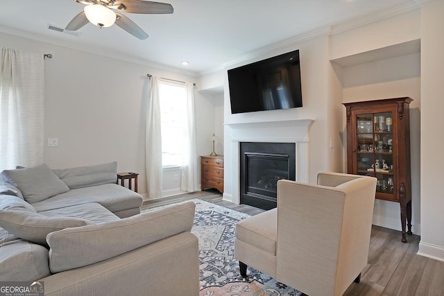 3323 Owl Creek Pkwy, Acworth, GA 30102 - living room with ornamental molding, wood finished floors, ceiling fan, a glass covered fireplace, and baseboards