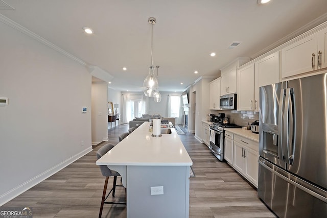 3323 Owl Creek Pkwy, Acworth, GA 30102 - kitchen featuring stainless steel appliances, crown molding, a breakfast bar, an island with sink, and open floor plan