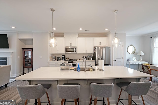 3323 Owl Creek Pkwy, Acworth, GA 30102 - kitchen with stainless steel appliances, wood finished floors, ornamental molding, a large island, and white cabinets