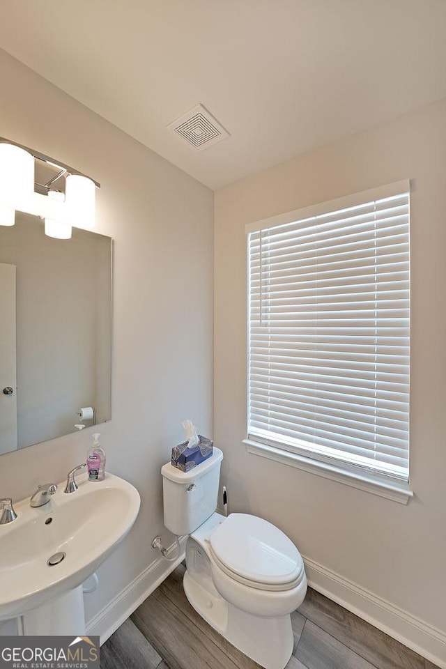3323 Owl Creek Pkwy, Acworth, GA 30102 - half bathroom with baseboards, toilet, wood finished floors, a sink, and healthy amount of natural light