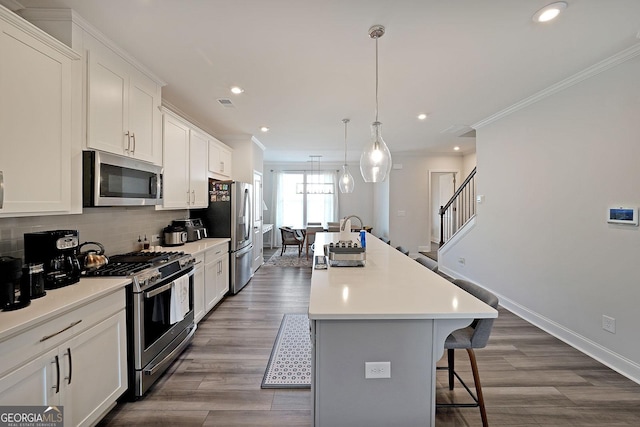 3323 Owl Creek Pkwy, Acworth, GA 30102 - kitchen with appliances with stainless steel finishes, a kitchen island with sink, a sink, a kitchen breakfast bar, and crown molding