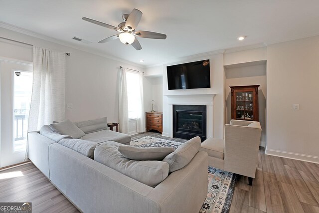 3323 Owl Creek Pkwy, Acworth, GA 30102 - living room with a ceiling fan, a glass covered fireplace, wood finished floors, crown molding, and recessed lighting