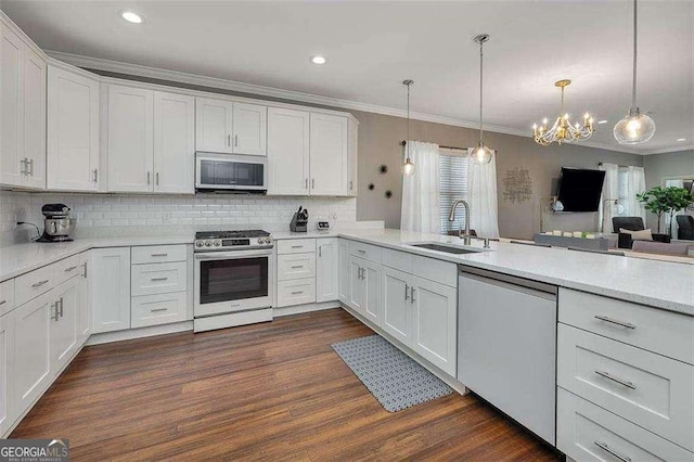 123 E Commons Dr, Saint Simons, GA 31522 - kitchen with gas stove, dishwasher, crown molding, white cabinetry, and a chandelier