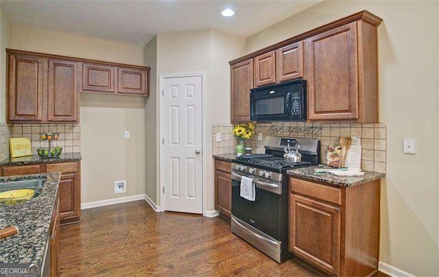 4854 Allston Ln, Peachtree Corners, GA 30092 - kitchen featuring stainless steel gas range, baseboards, dark stone counters, black microwave, and dark wood-style floors