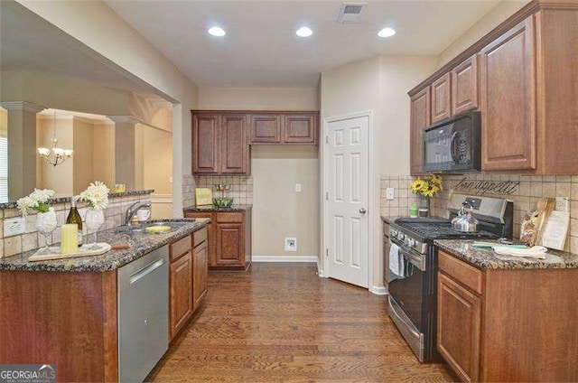 4854 Allston Ln, Peachtree Corners, GA 30092 - kitchen featuring stainless steel appliances, dark wood-type flooring, dark stone counters, a sink, and brown cabinetry