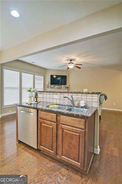 4854 Allston Ln, Peachtree Corners, GA 30092 - kitchen with dishwasher, a sink, a kitchen island with sink, and dark stone counters