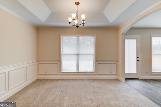 174 Livingston Ct, Winder, GA 30680 - spare room featuring a raised ceiling, a chandelier, arched walkways, carpet, and wainscoting