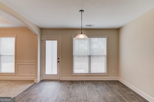 174 Livingston Ct, Winder, GA 30680 - unfurnished dining area featuring arched walkways, dark wood-style floors, and plenty of natural light