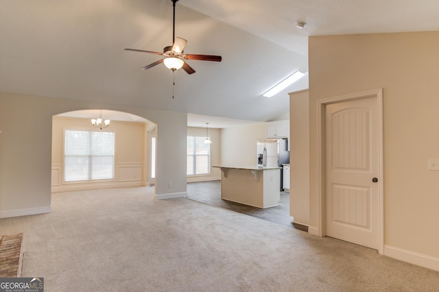 174 Livingston Ct, Winder, GA 30680 - unfurnished living room featuring arched walkways, light colored carpet, a ceiling fan, and lofted ceiling