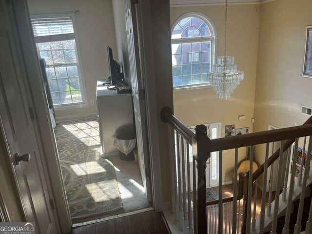 stairway featuring visible vents, a chandelier, and plenty of natural light