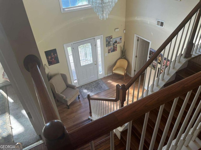 foyer entrance featuring a wealth of natural light, visible vents, wood finished floors, and stairway