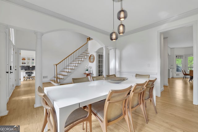 dining area with stairway, light wood-style flooring, visible vents, ornamental molding, and ornate columns