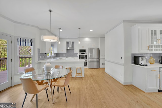 dining room featuring baseboards, light wood-type flooring, recessed lighting, and ornamental molding