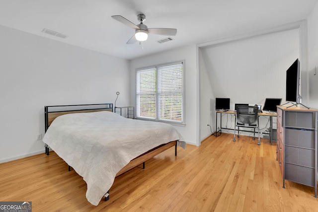 bedroom with baseboards, light wood finished floors, and visible vents