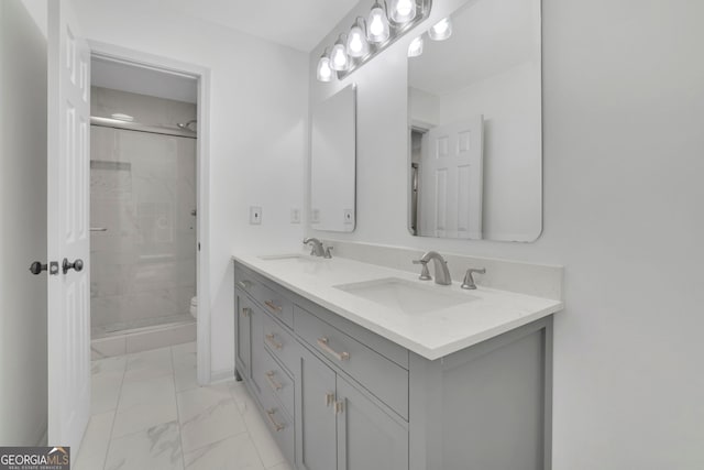 full bath with marble finish floor, a sink, toilet, and double vanity