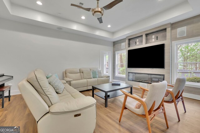 living room featuring a ceiling fan, plenty of natural light, light wood-style flooring, and visible vents