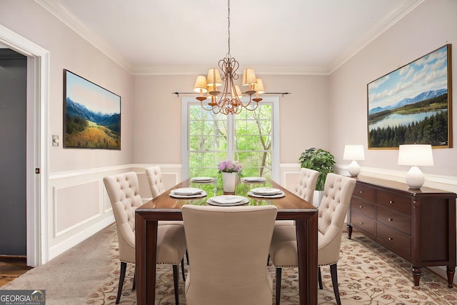 dining space with a chandelier, a decorative wall, ornamental molding, and a wainscoted wall