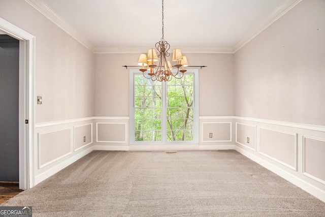 empty room with a notable chandelier, ornamental molding, a wainscoted wall, carpet floors, and a decorative wall