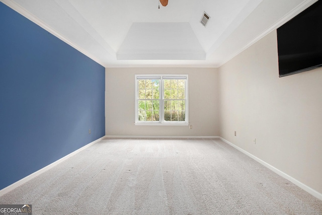 spare room featuring visible vents, a ceiling fan, a tray ceiling, and carpet flooring