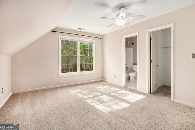 unfurnished bedroom featuring carpet flooring, lofted ceiling, a spacious closet, and visible vents