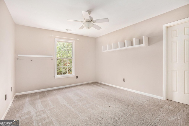 carpeted empty room featuring visible vents, ceiling fan, and baseboards