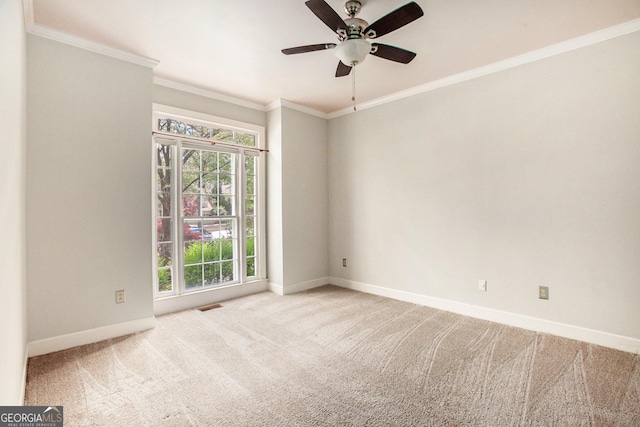 carpeted spare room featuring ornamental molding, visible vents, baseboards, and a ceiling fan