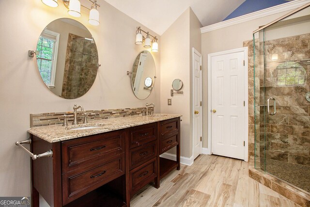 bathroom with a shower stall, vaulted ceiling, and a sink