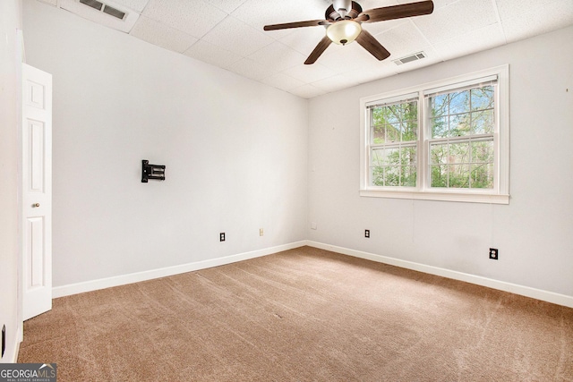 spare room featuring visible vents, a drop ceiling, and carpet