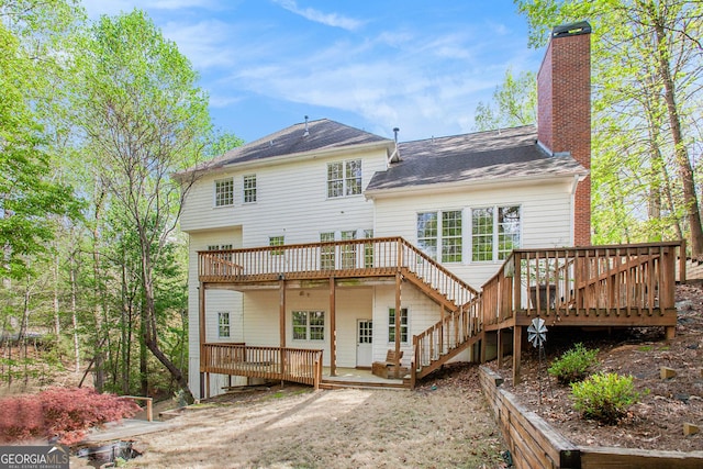 back of house featuring a wooden deck and a chimney
