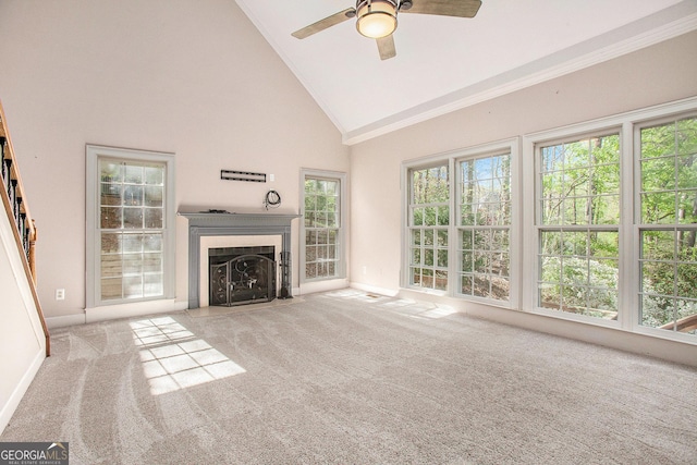 unfurnished living room featuring carpet floors, ceiling fan, high vaulted ceiling, and a fireplace with flush hearth