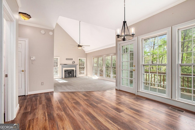 unfurnished living room featuring baseboards, a fireplace, visible vents, ceiling fan with notable chandelier, and wood finished floors