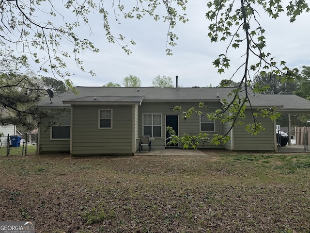 rear view of house featuring a gate, fence, and a patio