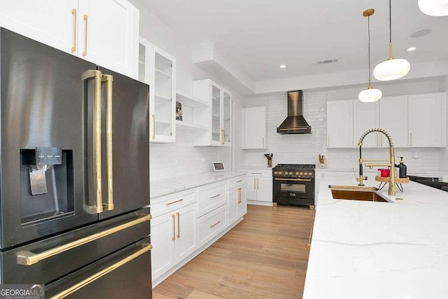 1598 Athens Ave SW, Atlanta, GA 30310 - kitchen with stainless steel fridge with ice dispenser, high end black range, wall chimney range hood, white cabinets, and decorative backsplash