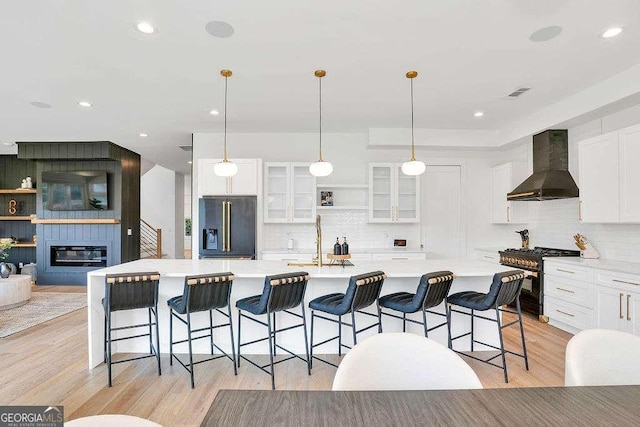 1598 Athens Ave SW, Atlanta, GA 30310 - kitchen with wall chimney exhaust hood, black fridge, high end stainless steel range, tasteful backsplash, and glass insert cabinets