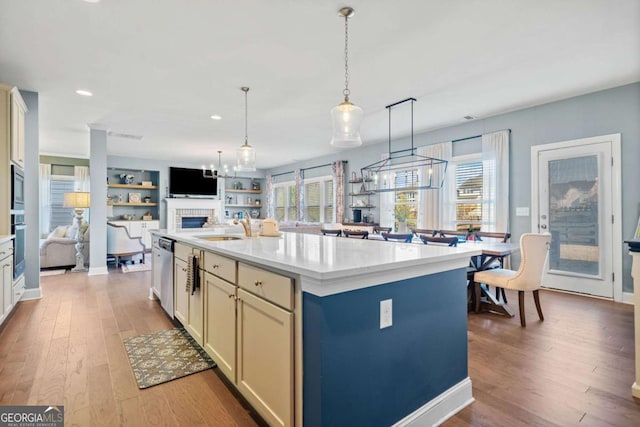 127 Crest Brooke Dr, Canton, GA 30115 - kitchen featuring light countertops, a sink, appliances with stainless steel finishes, open floor plan, and light wood-style floors