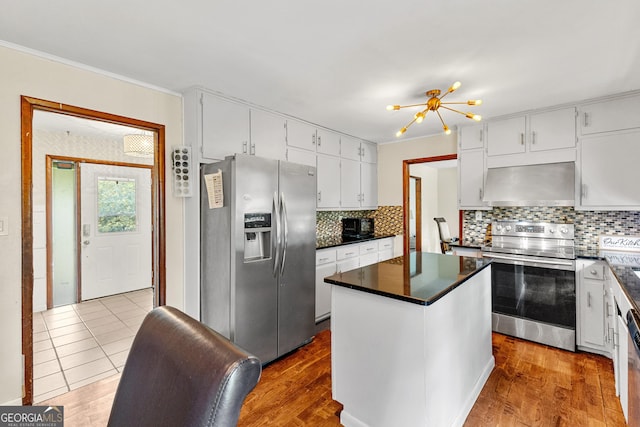 5429 Golfcrest Cir, Stone Mountain, GA 30088 - kitchen with white cabinetry, wall chimney exhaust hood, a center island, stainless steel appliances, and dark countertops