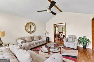 5429 Golfcrest Cir, Stone Mountain, GA 30088 - living room with wood finished floors, vaulted ceiling, and ceiling fan