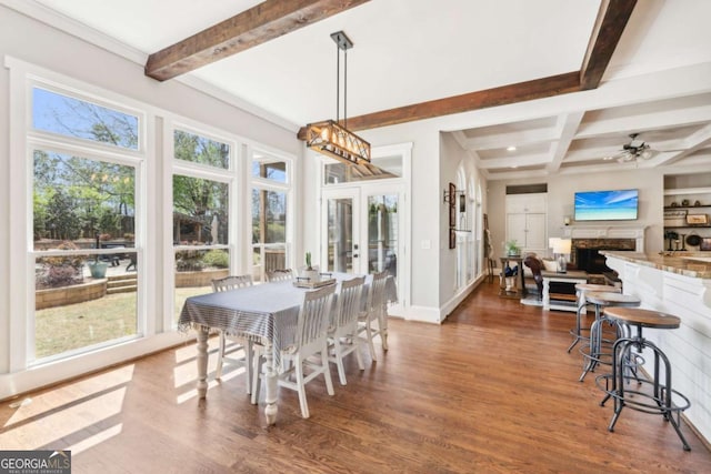 dining room with french doors, a fireplace, wood finished floors, baseboards, and beamed ceiling