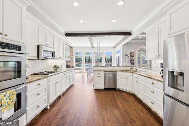 kitchen with a wealth of natural light, white cabinets, and appliances with stainless steel finishes
