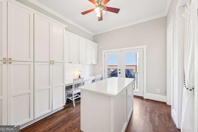 kitchen with dark wood-style floors, french doors, a center island, and ornamental molding