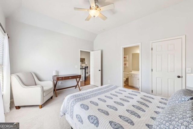 carpeted bedroom with ensuite bath, vaulted ceiling, and ceiling fan