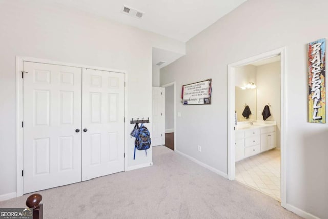 bedroom with a closet, baseboards, visible vents, and light carpet
