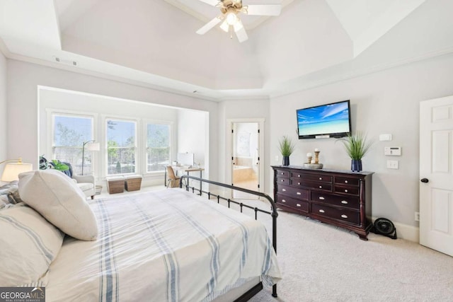 carpeted bedroom with a towering ceiling, a tray ceiling, baseboards, and ceiling fan