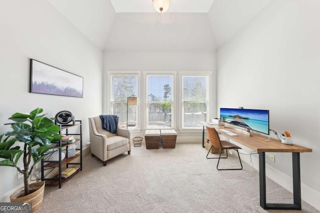 carpeted office space featuring baseboards and vaulted ceiling