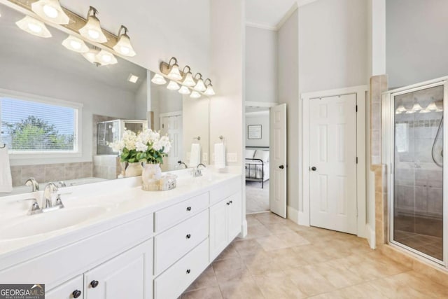 full bath featuring a stall shower, double vanity, a sink, and tile patterned floors