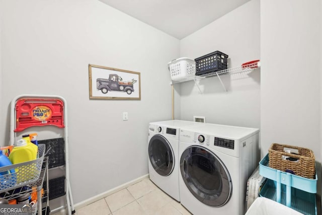 clothes washing area with washing machine and clothes dryer, baseboards, laundry area, and tile patterned flooring